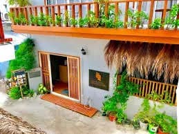 Plant-filled entrance and timber balcony at Sandy Heaven Maldives on Gulhi